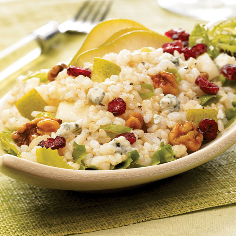 Pear and Walnut Rice Salad on a serving platter with drizzled Blue Cheese Vinaigrette.