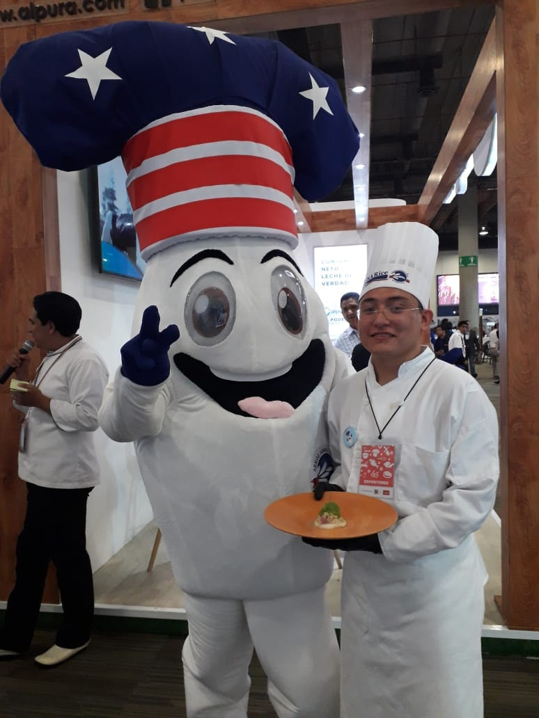 Rice mascot with big eyes and wide open mouth, wearing red, white & blue chef