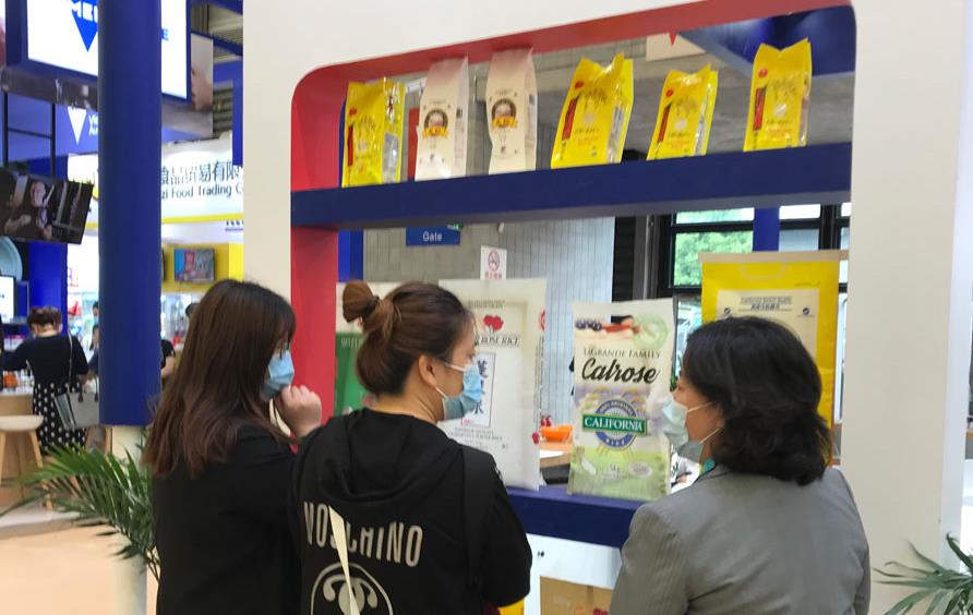 People stand in front of showcase with rice samples