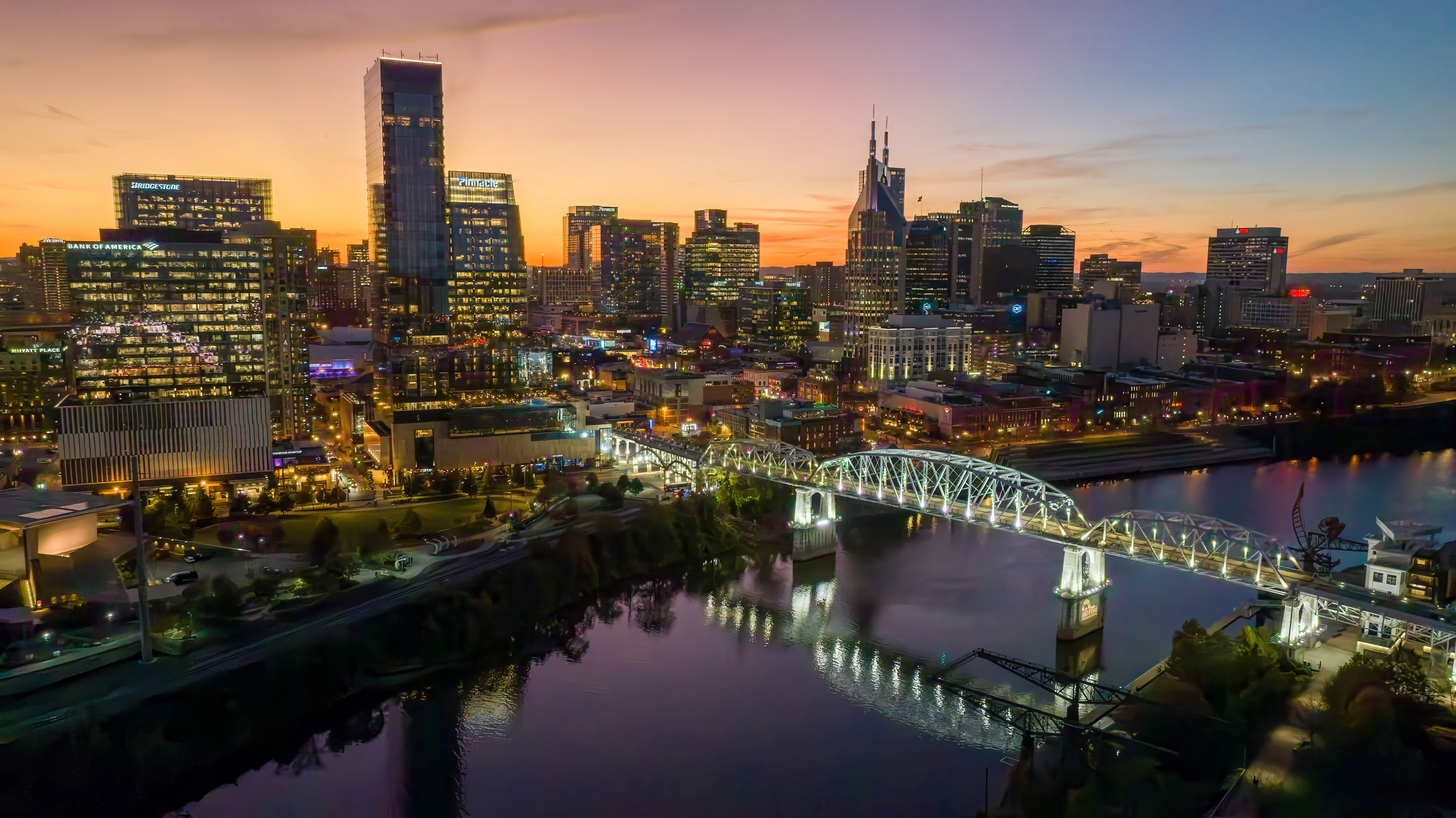 Nashville skyline at sunset with buildings and bridge lit up