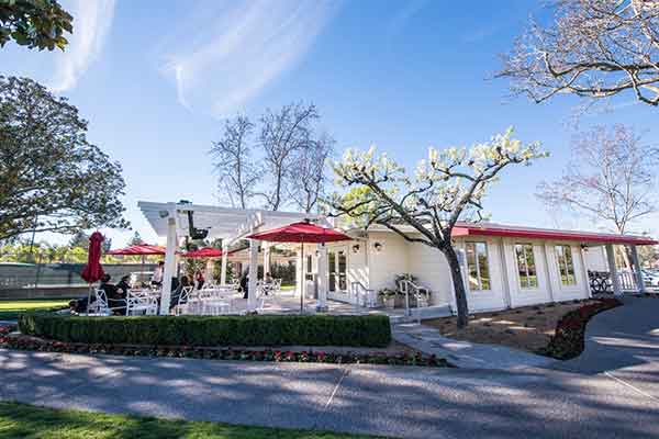 Outdoor view of a white building with red awning.