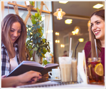 Image of two female college students in a dining hall.