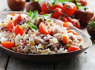 Side view of a healthy rice salad in a serving bowl.