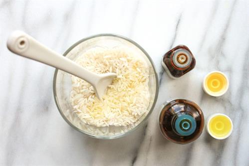 Overhead view of raw rice grains and essential oils.