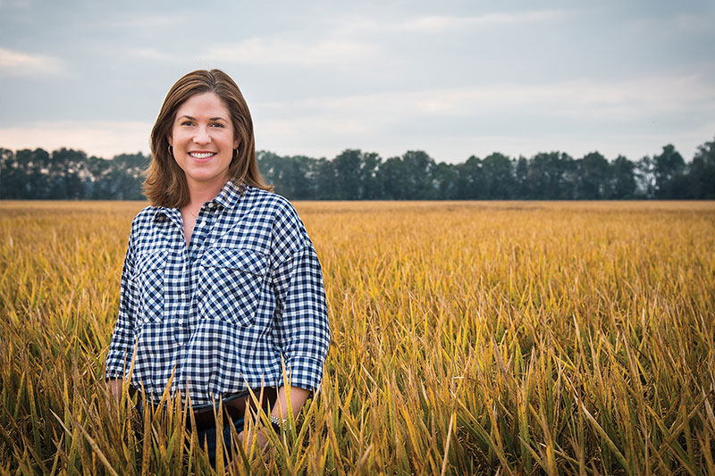 Rice farmer, Jennifer James, standing in a rice field.