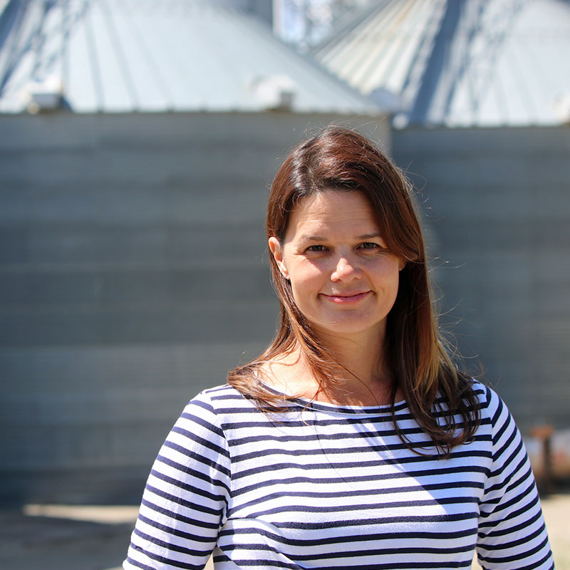 Rice farmer Kim Gallagher in front on grain bins.