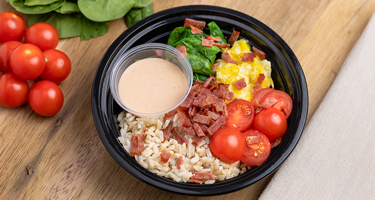 BLT Breakfast Rice Bowl Overhead view of a bowl containing rice, tomatoes, eggs, spinach, and bacon