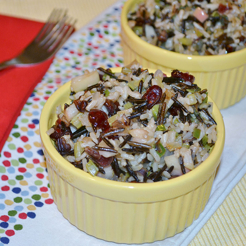 Side view of apple-sage wild rice stuffing in a yellow bowl.