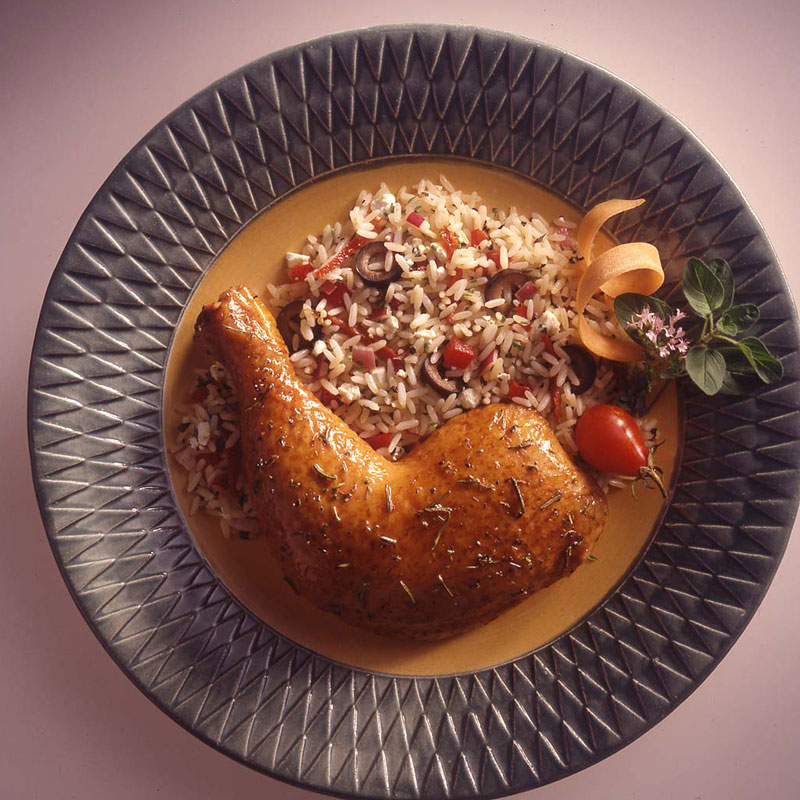 Overhead view of Athenian rice with feta cheese on a plate with roasted chicken.