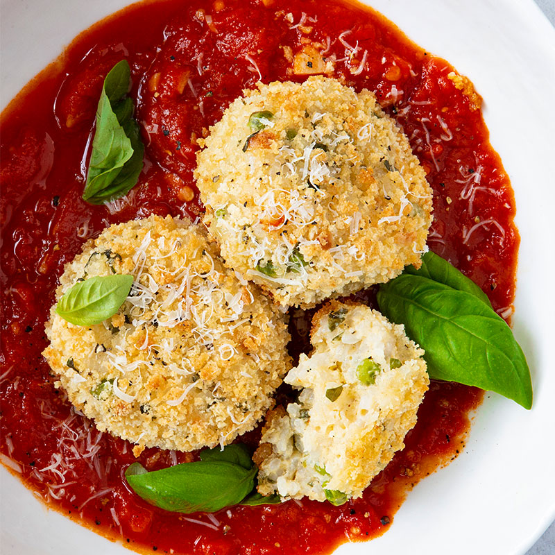 Baked Arancini with Spicy Tomato Sauce Overhead shot of a serving of Baked Arancini with Spicy Tomato Sauce.
