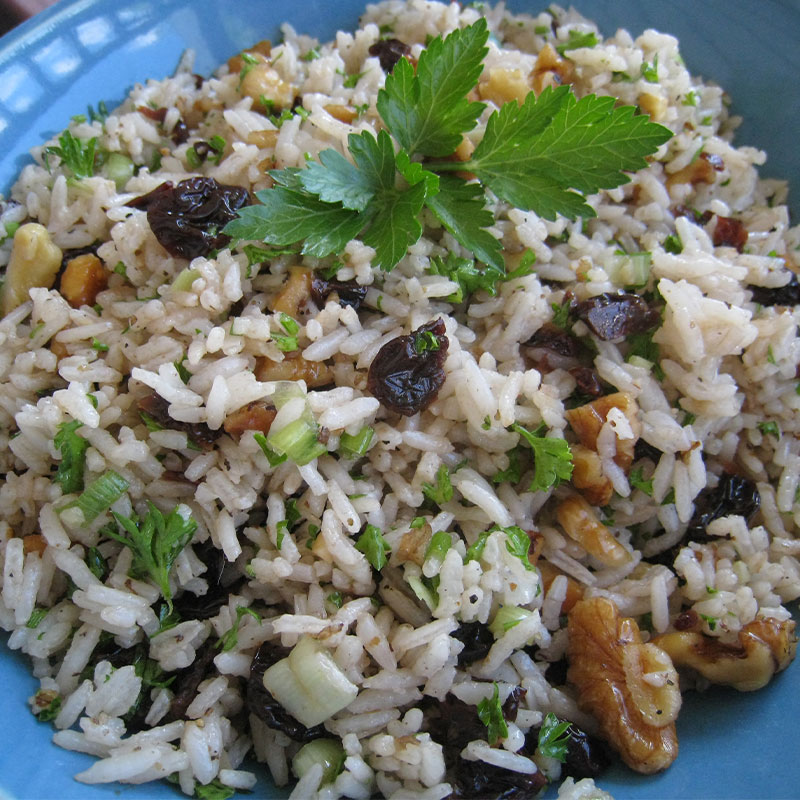Overhead image of Balsamic Cherry Rice Salad with Toasted Walnuts in a blue bowl.
