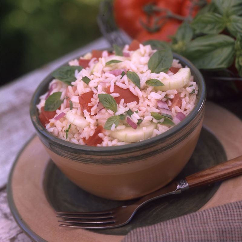 Side view of basil tomato rice salad in a bowl.