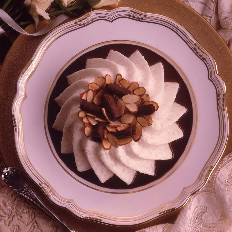 Overhead view of Bavarian rice cloud with bittersweet chocolate sauce on a white plate.