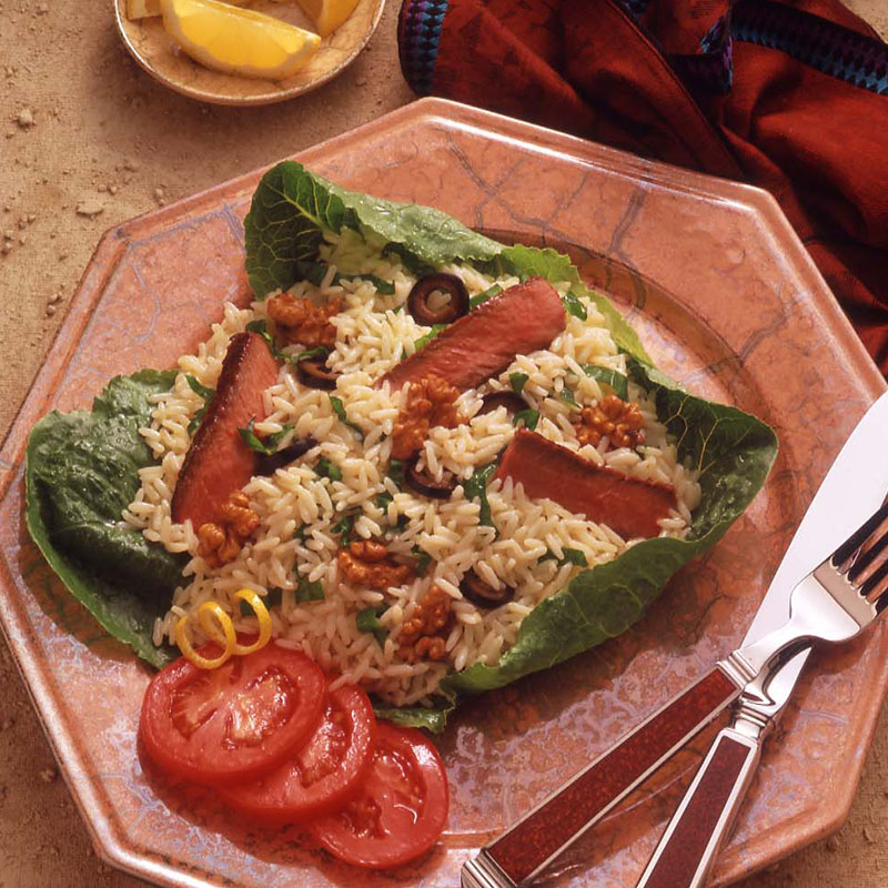 Overhead view of beef Caesar rice salad on a terracotta plate.