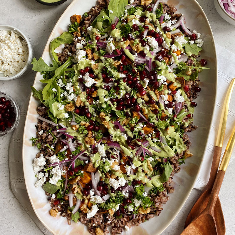 Overhead view of a platter of Black & Wild Rice Salad with Sweet Potatoes & Tahini sauce.