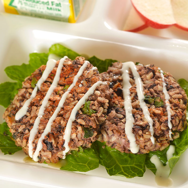 Overhead shot of Black Bean & Brown Rice Cakes on a bed of lettuce.