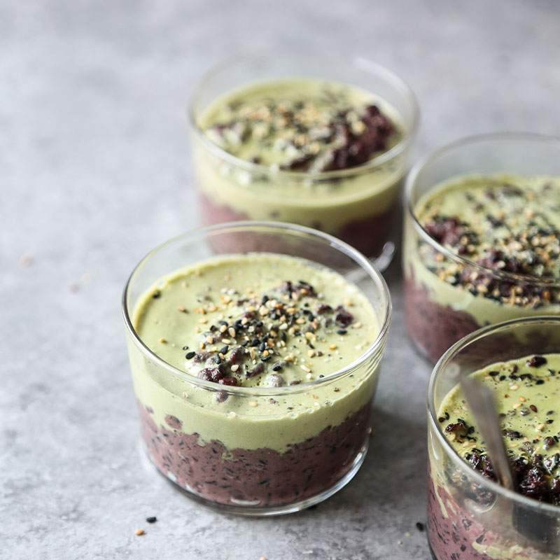 Black Sesame Coconut Rice Pudding Overhead shot of three cups filled with Black Sesame Coconut Rice Pudding with Matcha Cream.