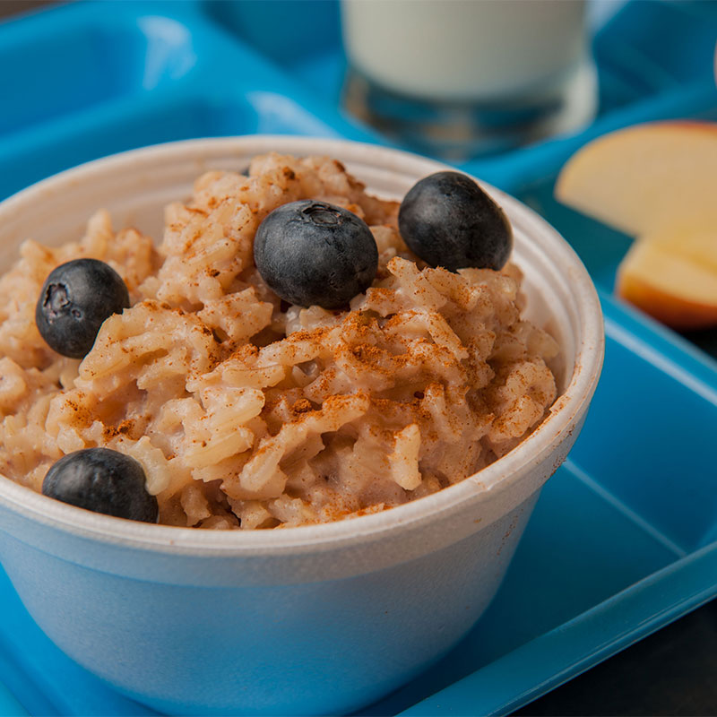 A serving of Breakfast Brown Rice on a blue cafeteria tray.