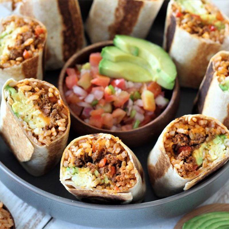 Image of a platter of rice breakfast burritos with salsa and guacamole.