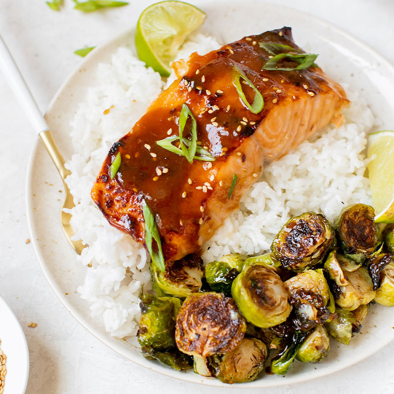 A cut of Brown Sugar Glazed Salmon on a bed of white rice.