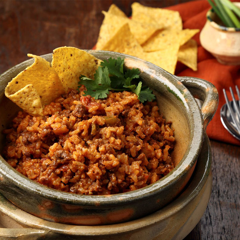 Side view of burrito and tortilla chip casserole in a bowl.