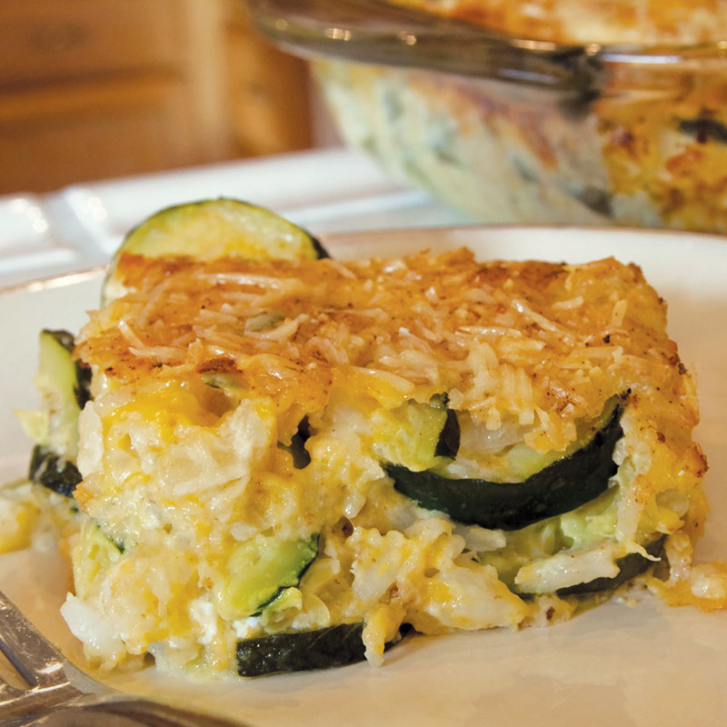 Side view of California rice and zucchini casserole on a white plate.