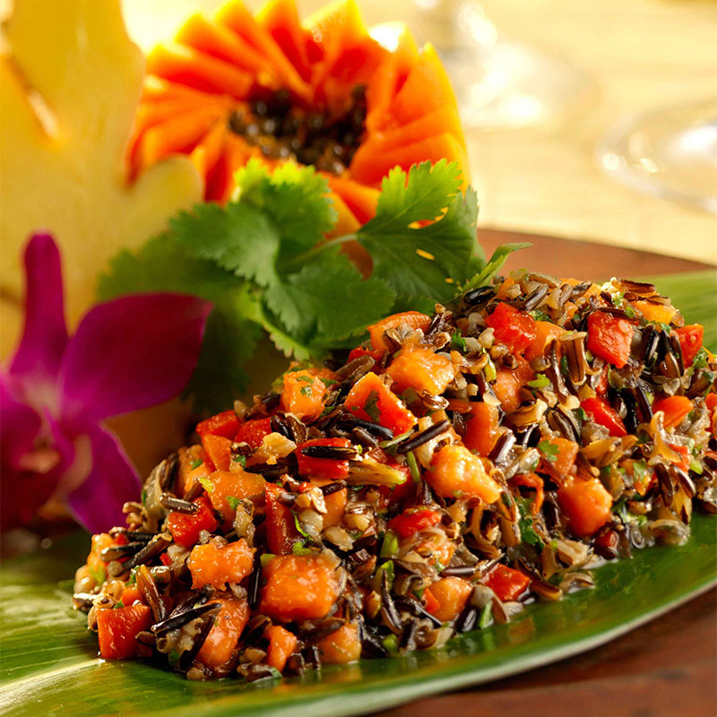 Colorful Gingered California Wild Rice and Papaya Salad on a green serving dish.