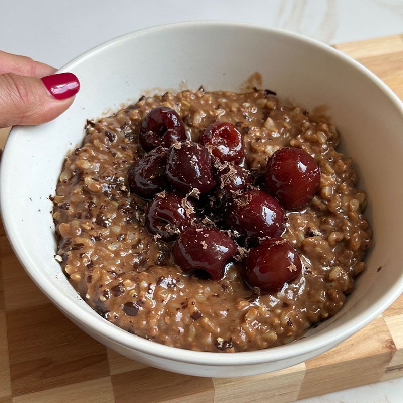 Zoomed in image of a bowl of Chocolate Cherry Breakfast Rice Pudding.