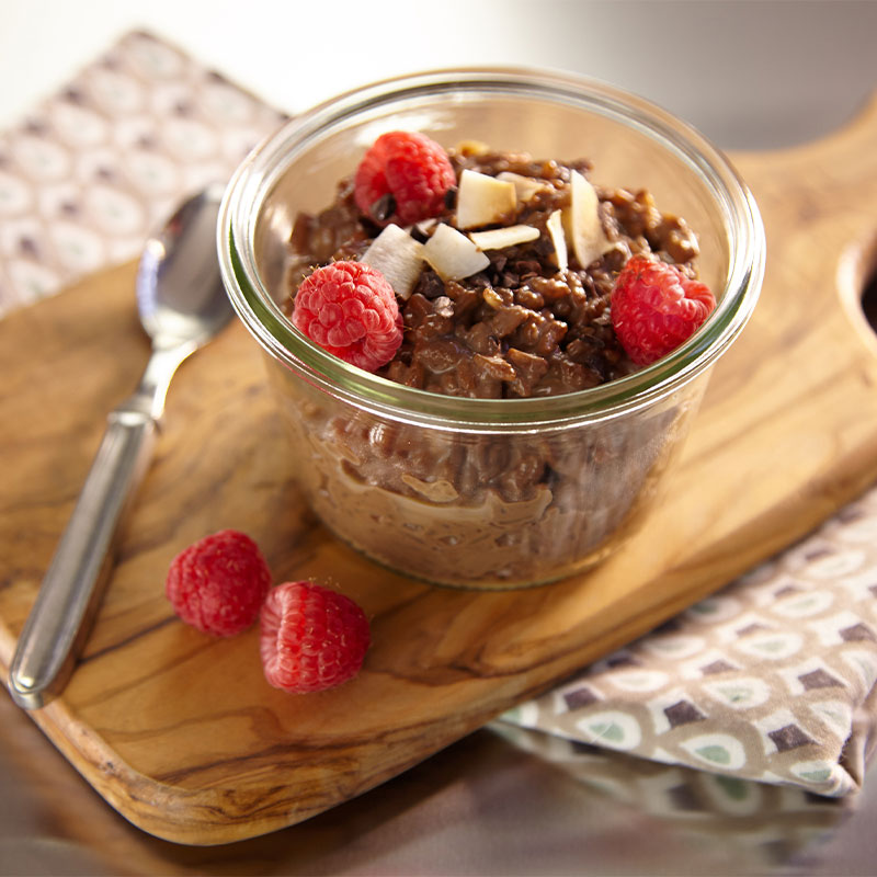 Chocolate Espresso Porridge topped with Raspberries in a glass jar. 