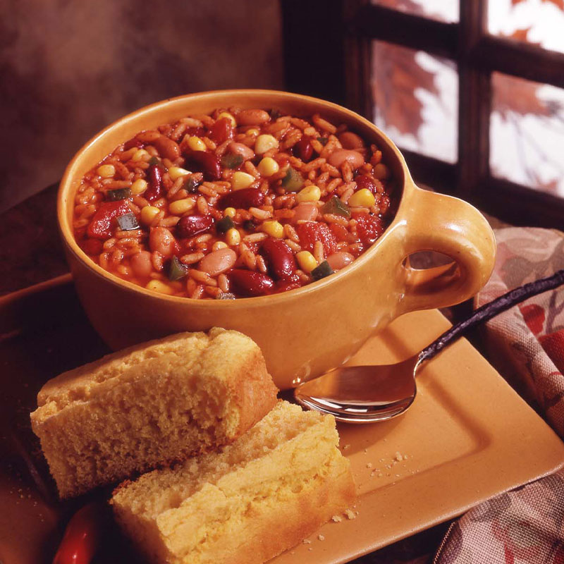 Overhead shot of a hot serving of Chunky Vegetarian Chili in a yellow cup.