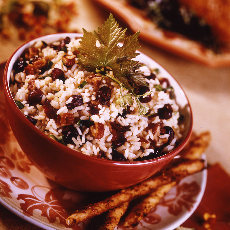 Close up view of cranberry pecan rice pilaf in a red bowl.