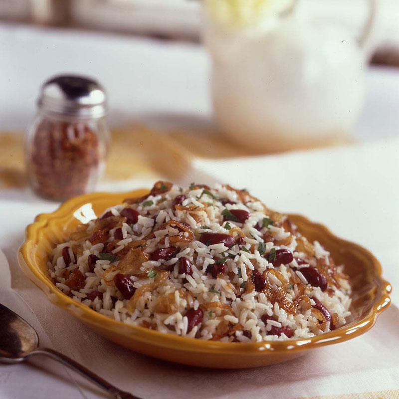 Side shot Creamy Red Beans and Rice with Caramelized Onions in a yellow dish.