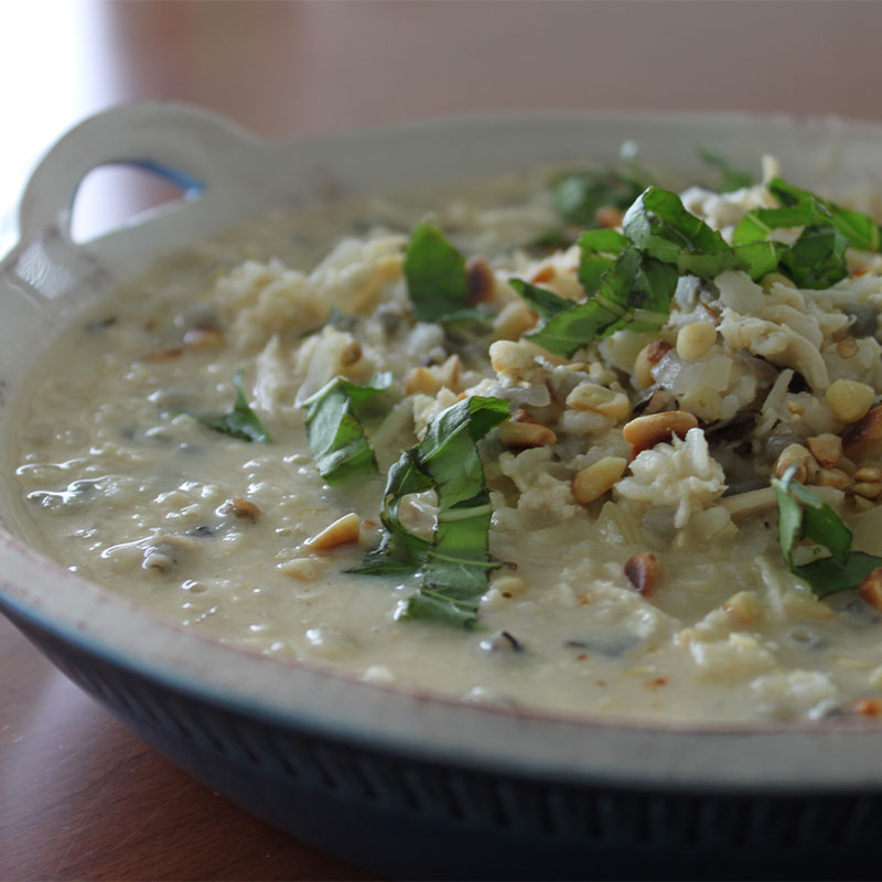 Creamy Tuscan Chicken Wild Rice Bisque topped with pine nuts and basil.