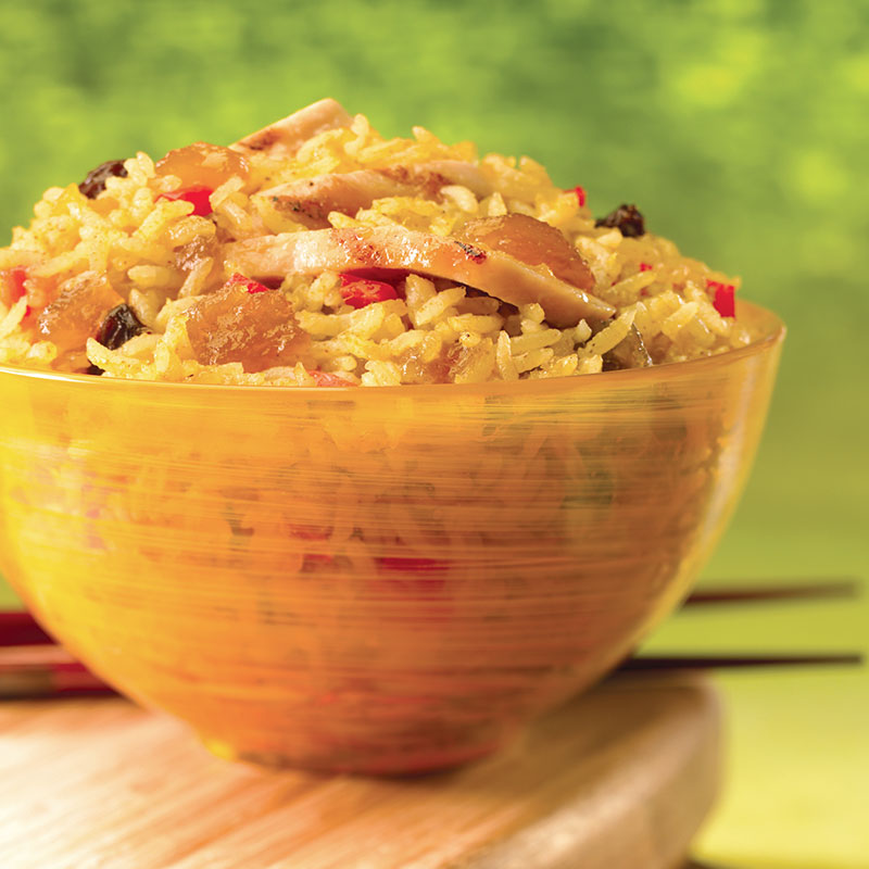 Side view of curry chicken lime rice in a yellow bowl.