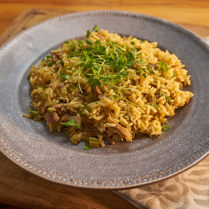 Side view of dirty duck rice in a grey bowl.