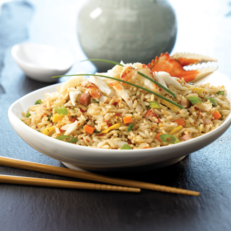 Dungeness Crab Fried Rice Side view of Dungeness crab fried rice in a white bowl.