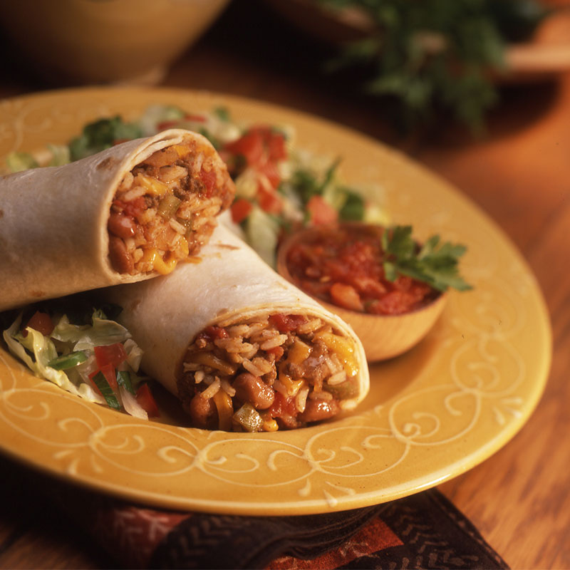 Close up view of easy cheesy rice burrito on a yellow plate.
