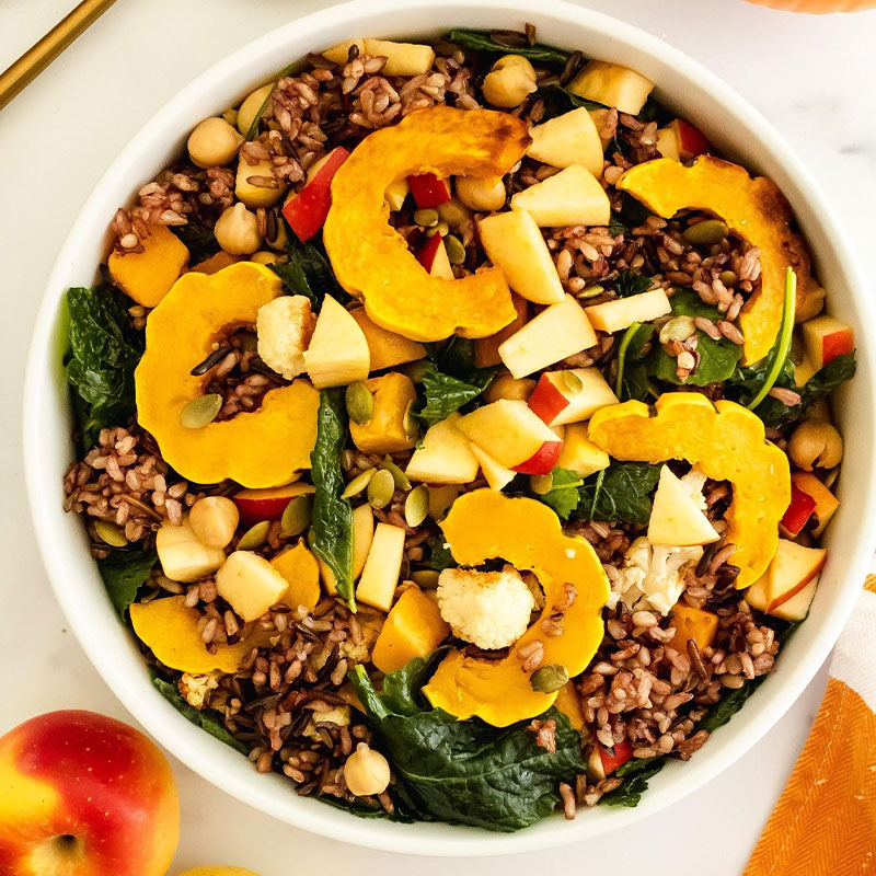 Fall Wild Rice Pilaf Overhead shot of a fall colored Wild Rice salad topped with squash, pumpkin, and apple pieces.