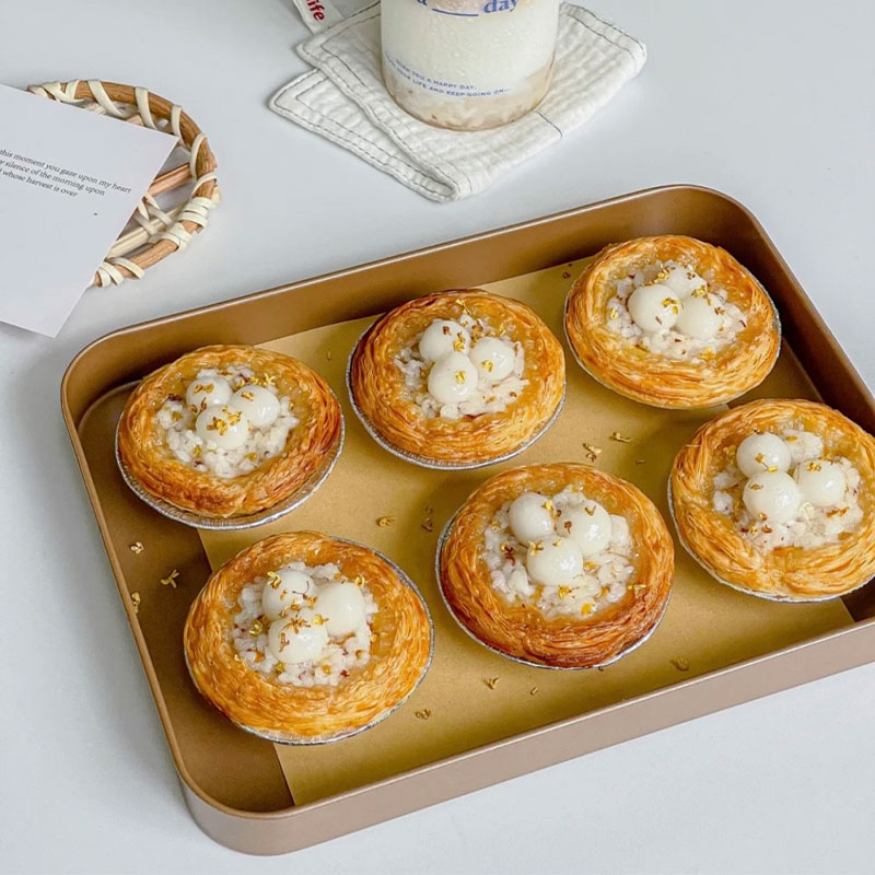 View of a baking pan with six Fermented Rice Egg Tarts.