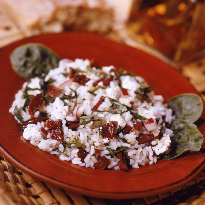 Side overhead shot of Greek Garden Rice Salad in a red bowl.