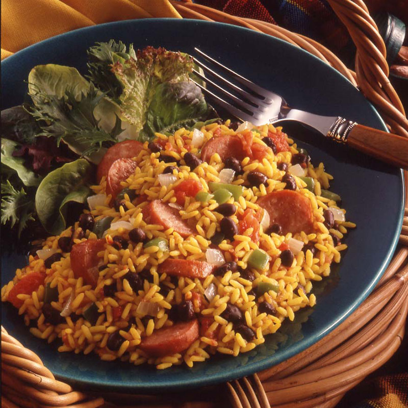 Side view of Havana rice and beans with salad greens on a blue plate.