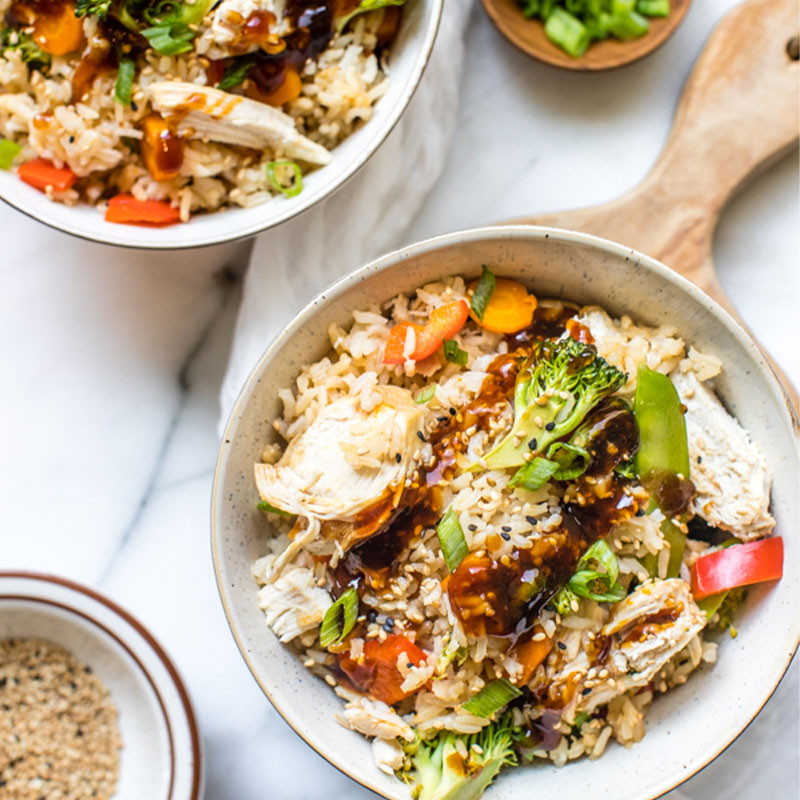 Overhead shot of a Teriyaki Chicken Rice Bowl with broccoli and green onion. 