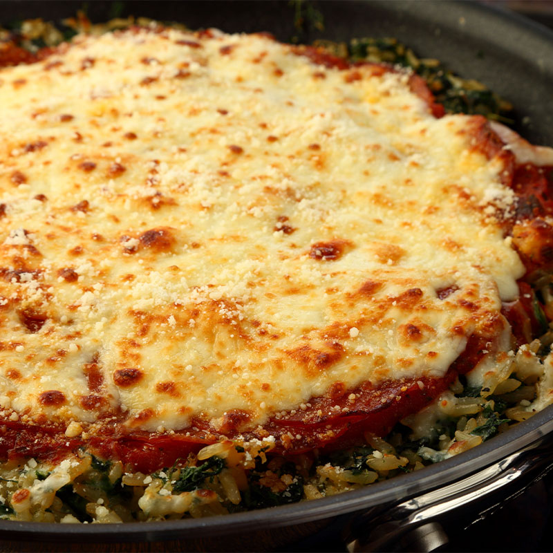 A full Italian Pepperoni Rice Bake in a pan on top of the stove.