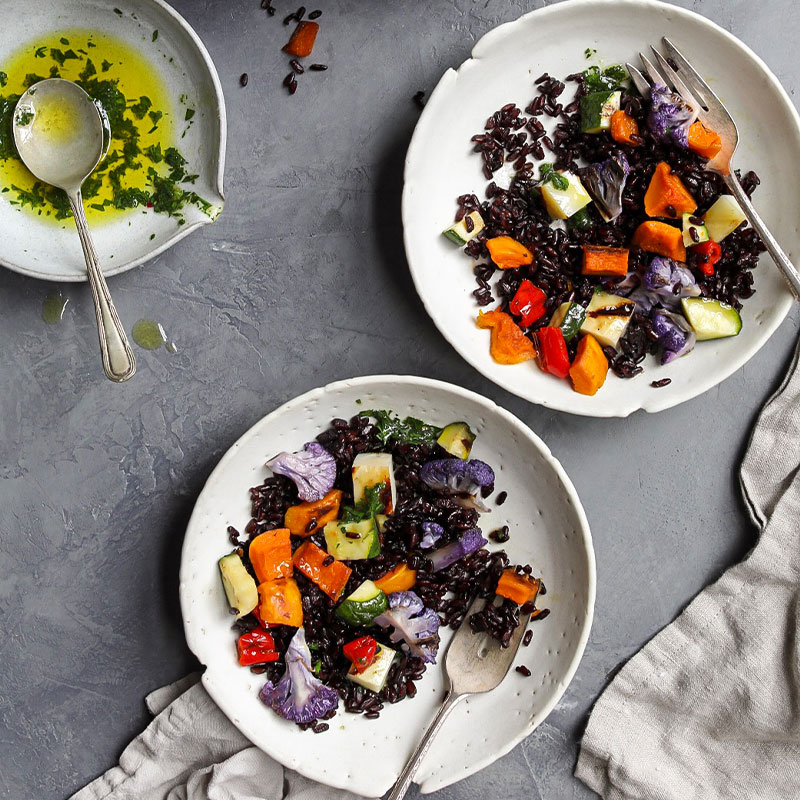 Overhead shot of bowls full of colorful Japonica Rice Salad with Roasted Vegetables.