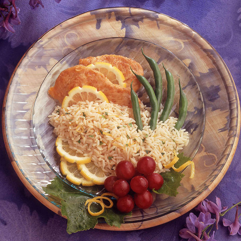 Overhead view of lemon rice with baked salmon and green beans on a plate.