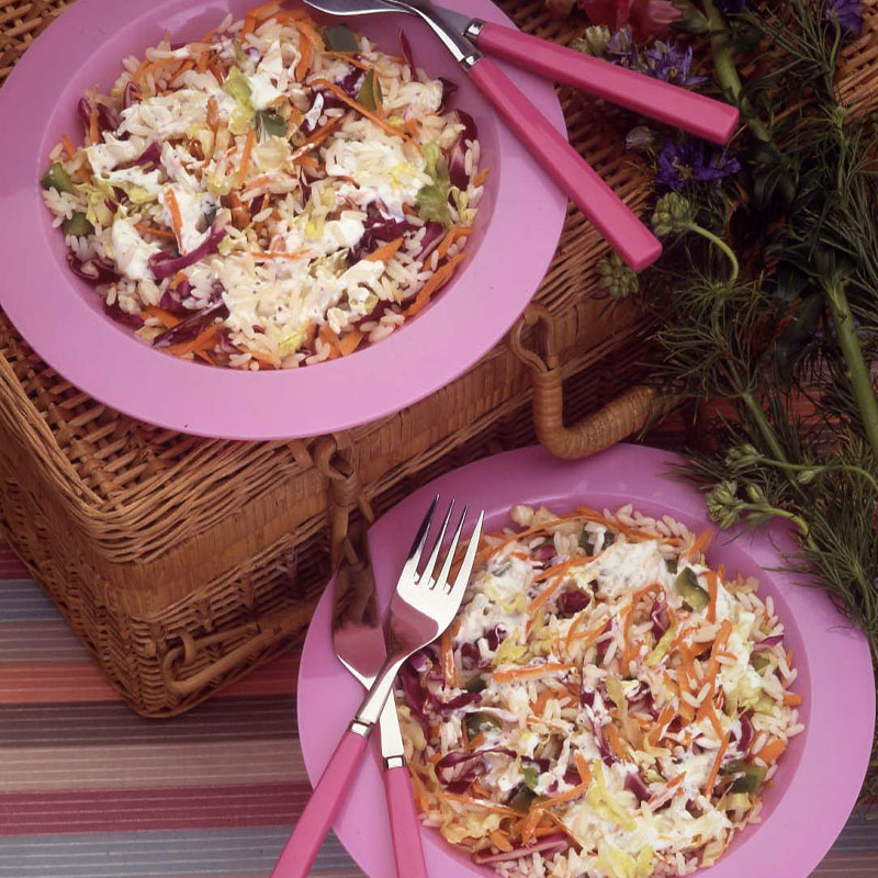 Overhead shot of Mardi Gras Salad in a purple bowl with silverware to the side.