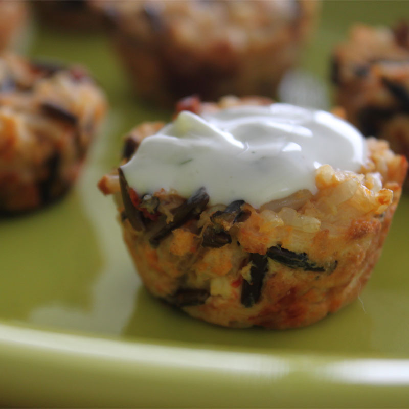 A close up image of a single Mediterranean Chicken and Wild Rice Cup on a plate full of them.