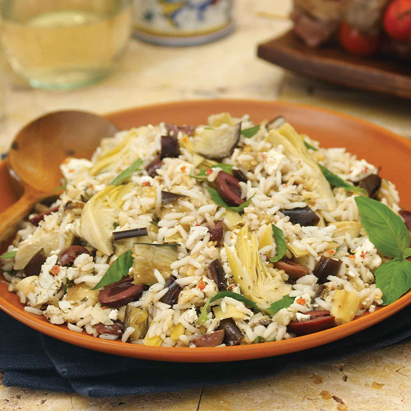 A large serving of Mediterranean Eggplant, Artichoke and Feta Rice Salad on a brown plate.