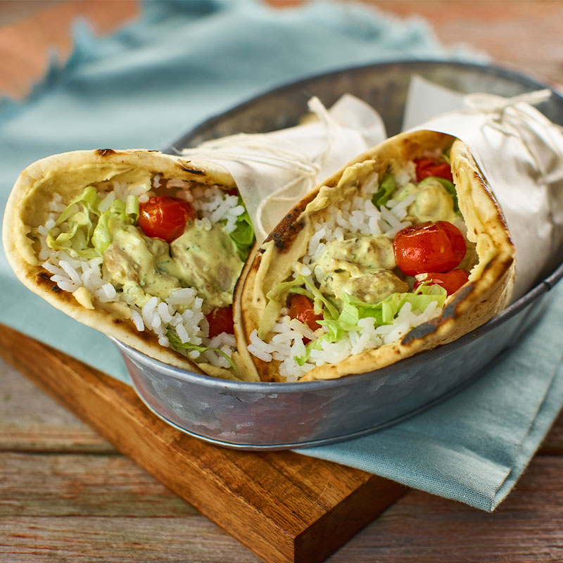 Two wrapped Mediterranean Pita Sandwiches in a serving basket.