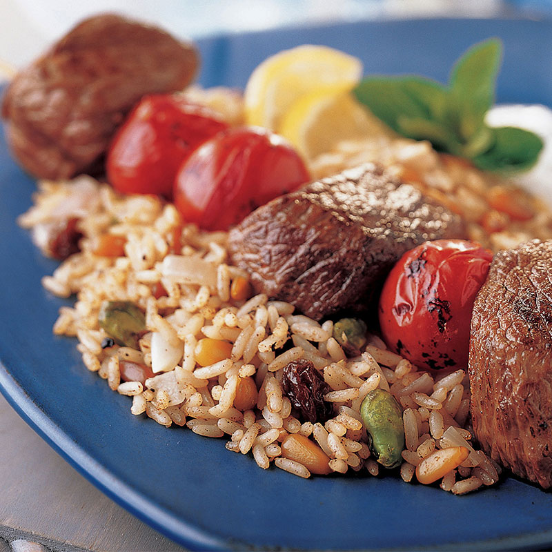 Close up view of Moroccan lamb and rice on a blue plate.